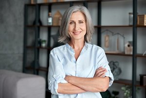 Smiling woman with mid-length grey hair wearing a light blue shirt